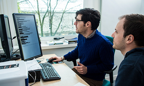 Employee and consultant analysing a computer screen in an office