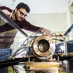 Researcher operating a vibration test rig