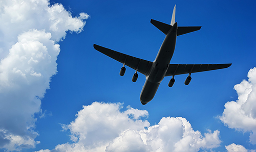 Airplane silhouette in deep blue sky