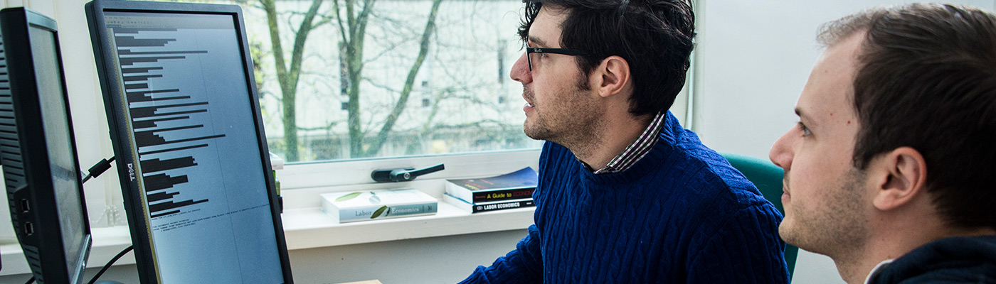 Employee and advisor analysing a computer screen in an office