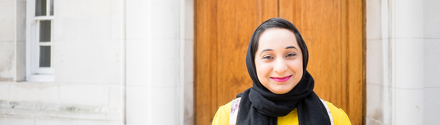 Female student smiling in front of University building