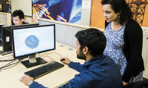 Researchers looking at computer simulation on a monitor