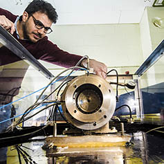 Researcher monitoring equipment in the dynamics lab