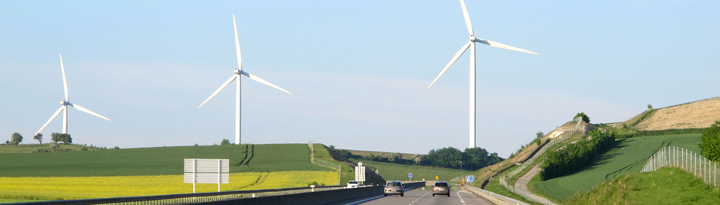 Wind turbines in a field overlooking a dual carriageway