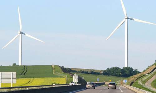 Wind turbines in a field overlooking a dual carriageway