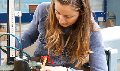 A female researcher bending down to operate equipment