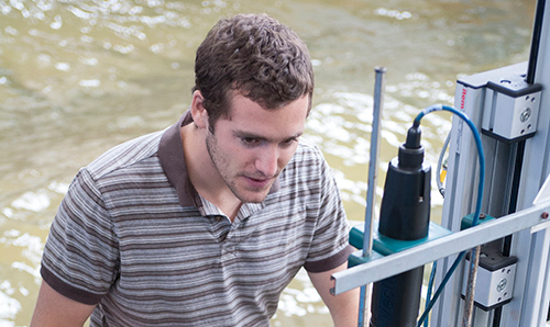 A researcher carrying out an experiment, knee-deep in water