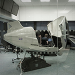 View of two people working in flight simulator from the outside